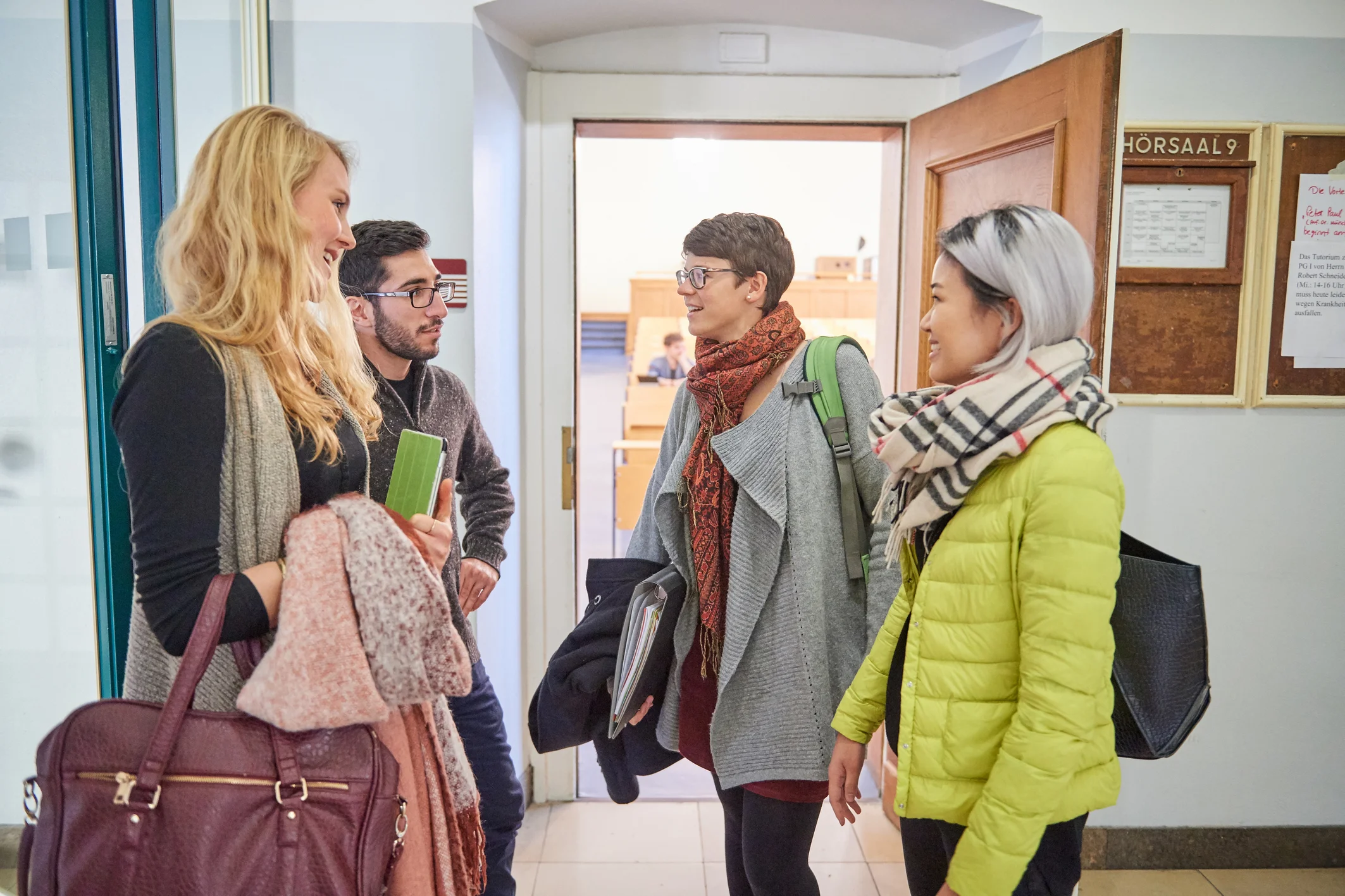 Vier Studierende vor einem Hörsaal.jpg
