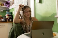 Frau mit Kopfhörer und Laptop